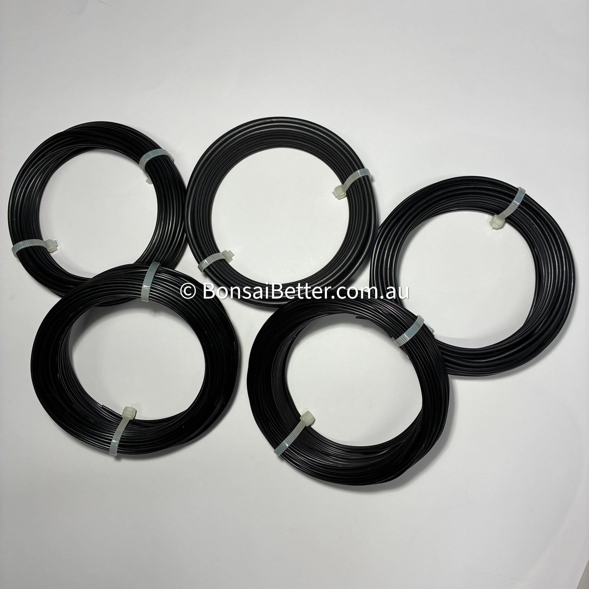 Five coils of black wire on a white background